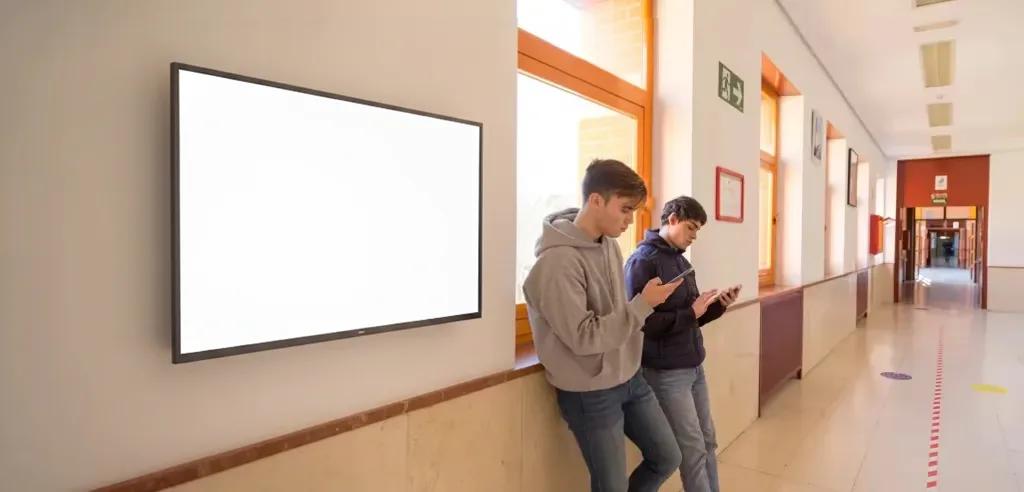 Schüler im Schulflur vor ScreenWay Display mit aktuellen Informationen
